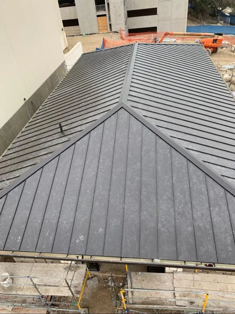 Commercial metal roof construction with crane equipment in Charleston